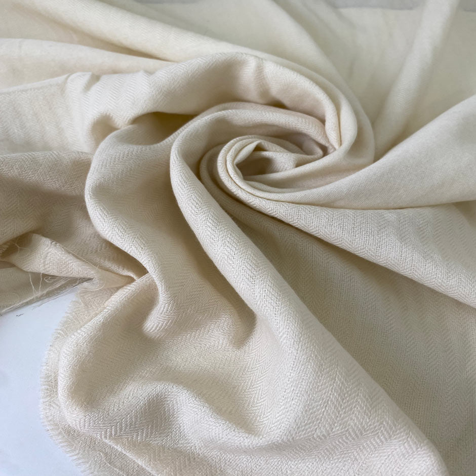 Pure wool pashmina in a soft unbleached cream tone. Very light and delicate, ideal for shawls, scarves, shirting, and dresses. High-quality deadstock collected in Stock from a Maison de Couture in Italy.