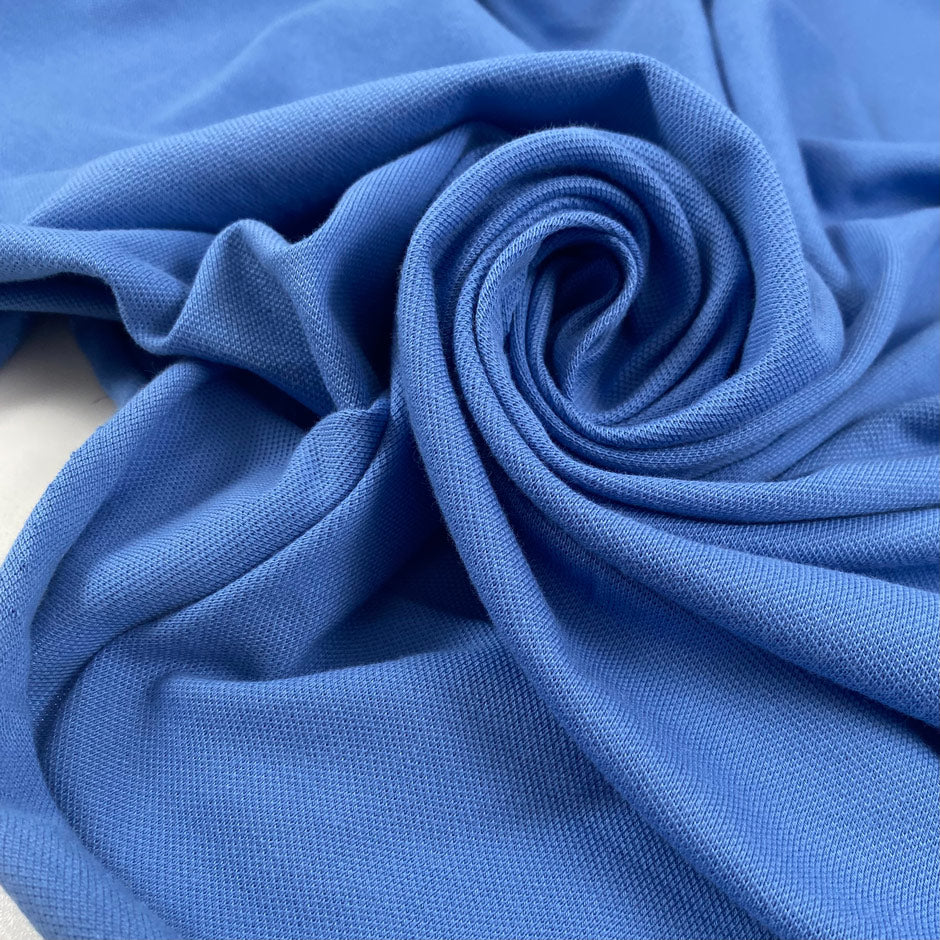 Pure cotton stretch jersey piquet in light blue color reference Cornflower Blue. Soft, textured, and comfortable. Ideal for dresses, trousers, and skirts. High-quality deadstock collected in Stock from a Maison de Couture in Italy.