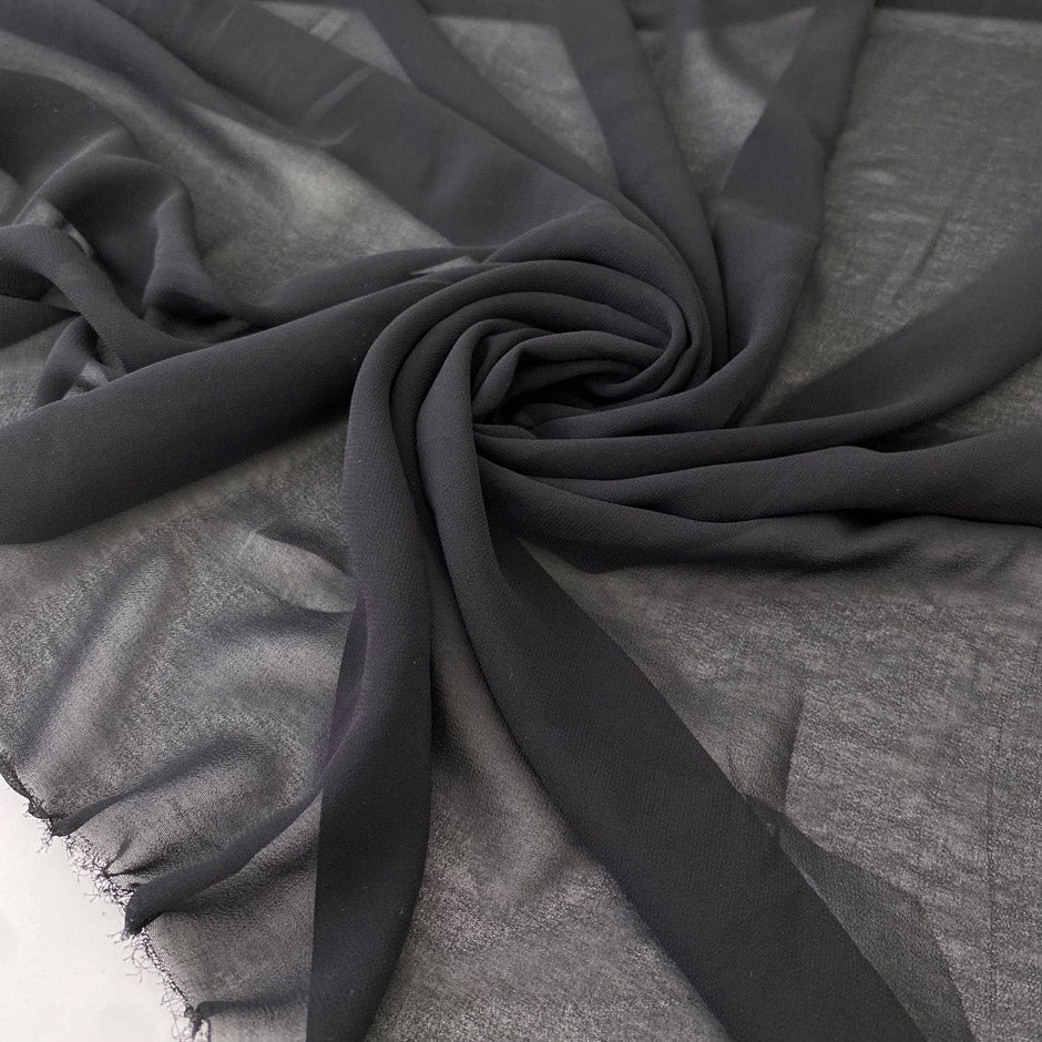 Polyester georgette in black. Very light, soft, and flowy with transparent finish. Ideal for shirting, dresses, and skirts. High-quality deadstock collected in Stock from a Maison de Couture in Italy.