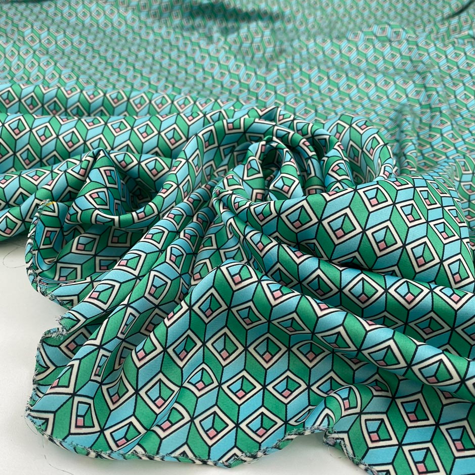 Very soft, smooth, and light polyester satin with a small geometric design in shades of light blue, green, and pink. Not transparent. High-quality deadstock collected in Stock from a Maison de Couture in Italy.