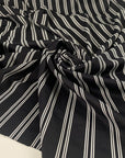 Black base Punto Milano polyester with double white lines. The fabric is stretch. High-quality deadstock collected in Stock from a Maison de Couture in Italy.