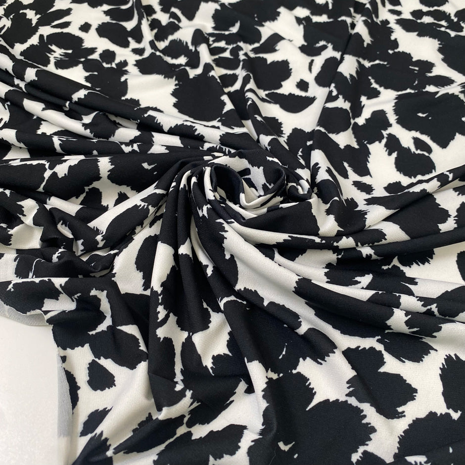 Printed polyester jersey with black spots on a white base soft and fluid ideal for tops dresses and layering pieces. High-quality deadstock collected in Stock from a Maison de Couture in Italy.