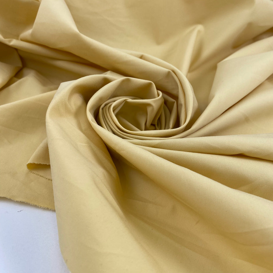 Cotton polyester fabric in pale banana yellow, very crunchy, light, and not transparent, ideal for shirts, dresses, and structured pieces. High-quality deadstock collected in Stock from a Maison de Couture in Italy.