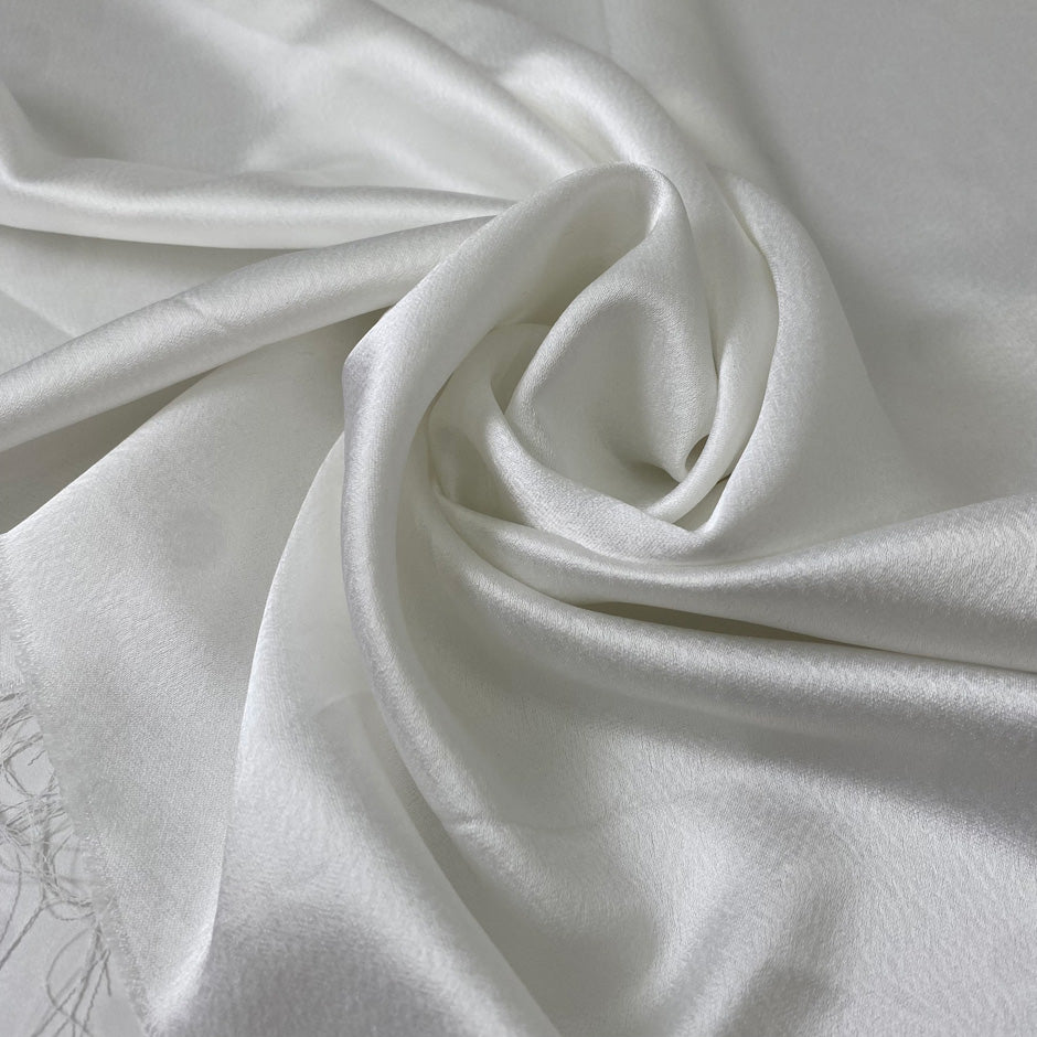 Soft and flowy white polyester cady with a shiny face and matte back. Not transparent, ideal for dresses, skirts, and trousers.High-quality deadstock collected in Stock from a Maison de Couture in Italy.