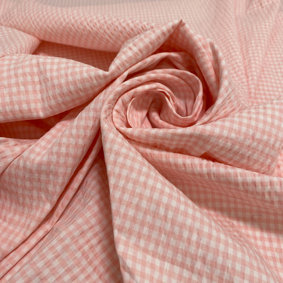 Cotton and polyester blend with stretch in a white and pink checked seersucker texture. Soft and fresh, ideal for dresses, skirts, trousers, and blouses.High-quality deadstock collected in Stock from a Maison de Couture in Italy.