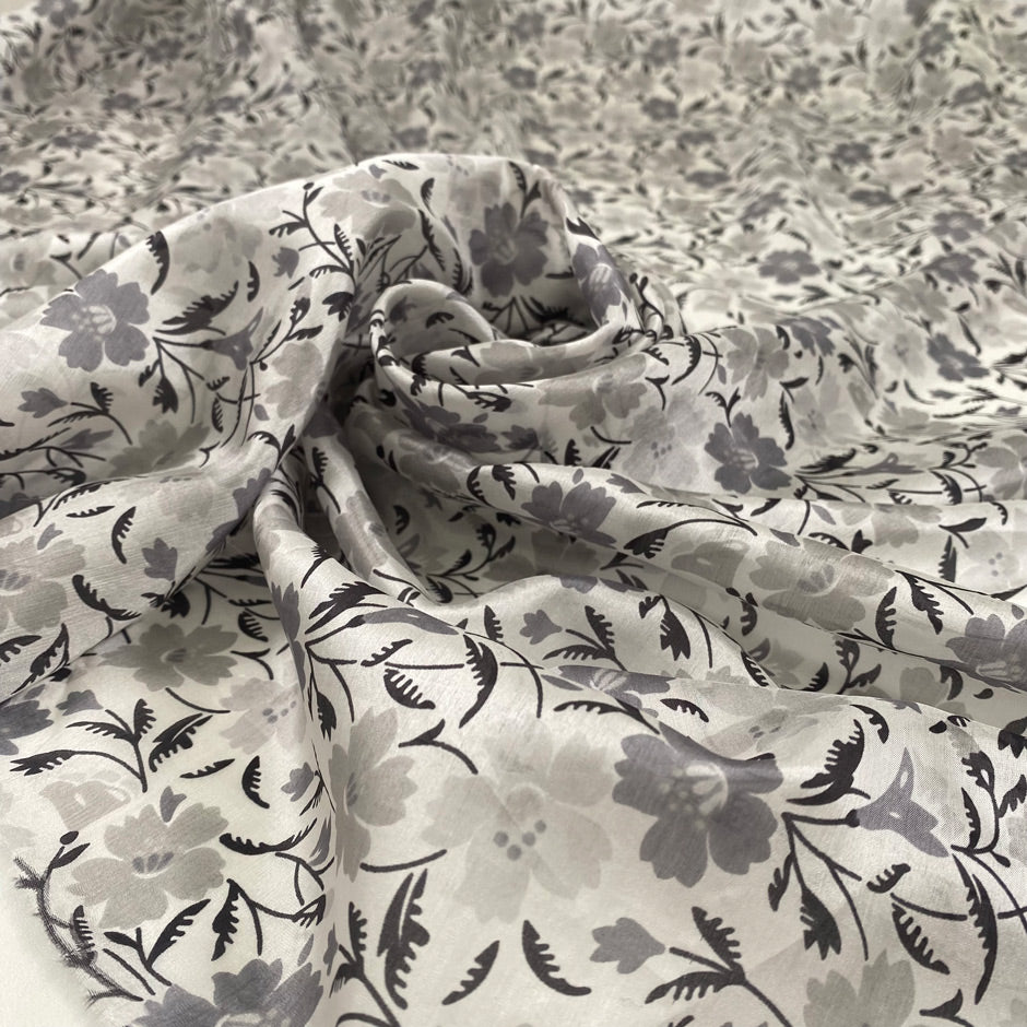 Pure silk with white ground and the flower design is in shades of gray. Very light, soft and semitrasparent. High-quality deadstock fabric collected in Stock from a Maison de Couture in Italy.