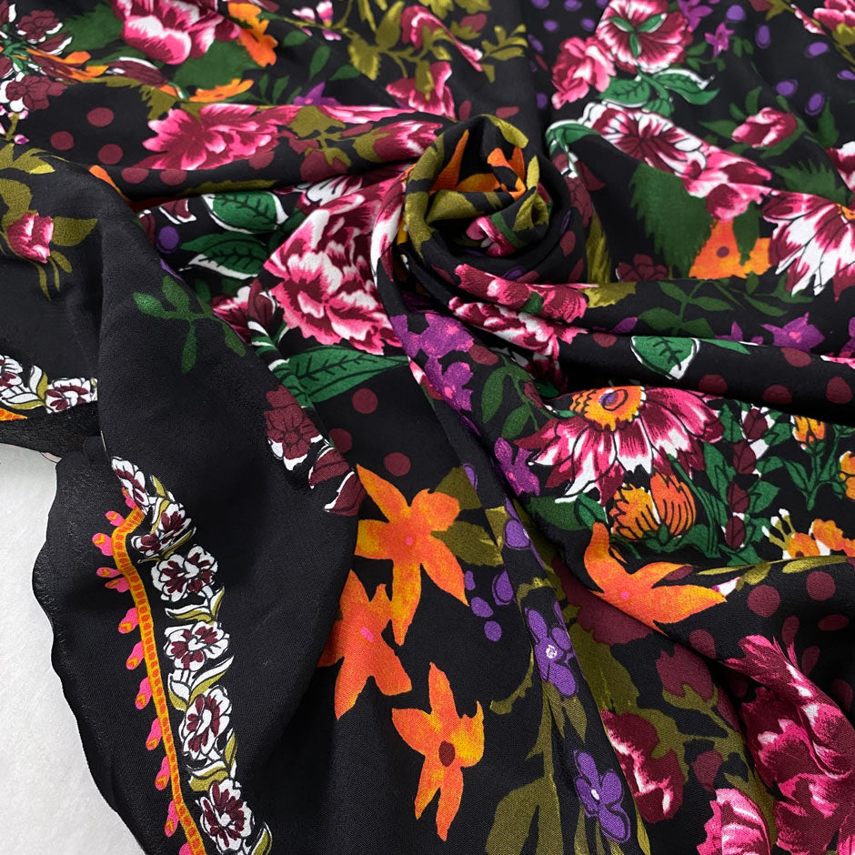 Pure viscose with floral design in panels. The ground is black and the print is in the shades of green, orange, dark red, and fuchsia. Very soft, light, and flowy. Ideal for dresses, skirts, and blouses. High-quality deadstock collected in Stock from a Maison de Couture in Italy.