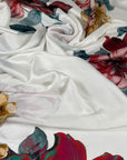 Polyester satin with a white base and large floral print in red, green, gray, pink, and beige. Light, flowy, slightly shiny, not transparent. High-quality deadstock collected in Stock from a Maison de Couture in Italy.