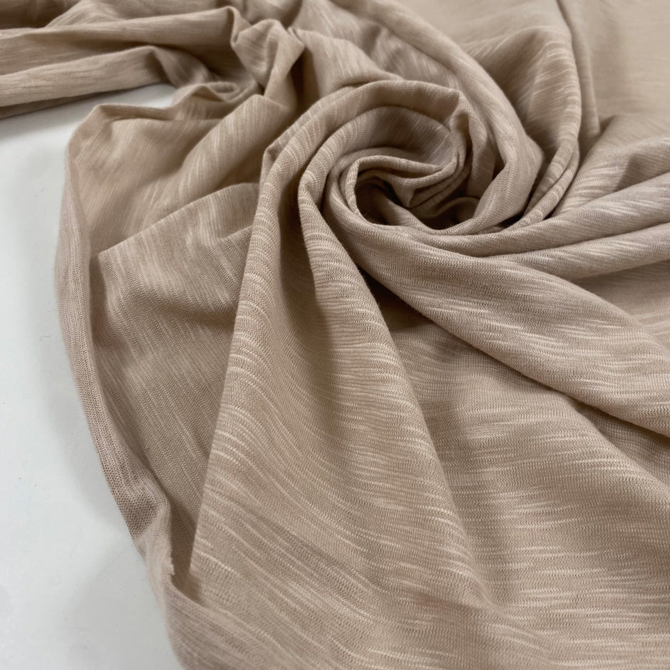 Pure cotton stretch jersey in pink beige, color reference Shell. Very soft and flowy with a slightly rough texture. High-quality deadstock collected in Stock from a Maison de Couture in Italy.