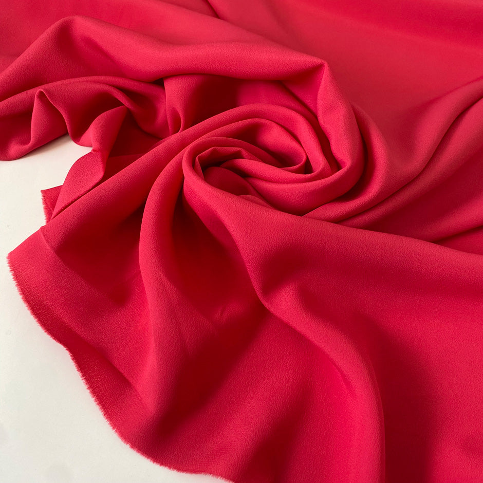 Silk and acetate crepe de chine in fuchsia color, reference Innuendo. Very soft, light and flowy, not transparent. Ideal for shirting, blouses, dresses, and skirts. High-quality deadstock collected in Stock from a Maison de Couture in Italy.