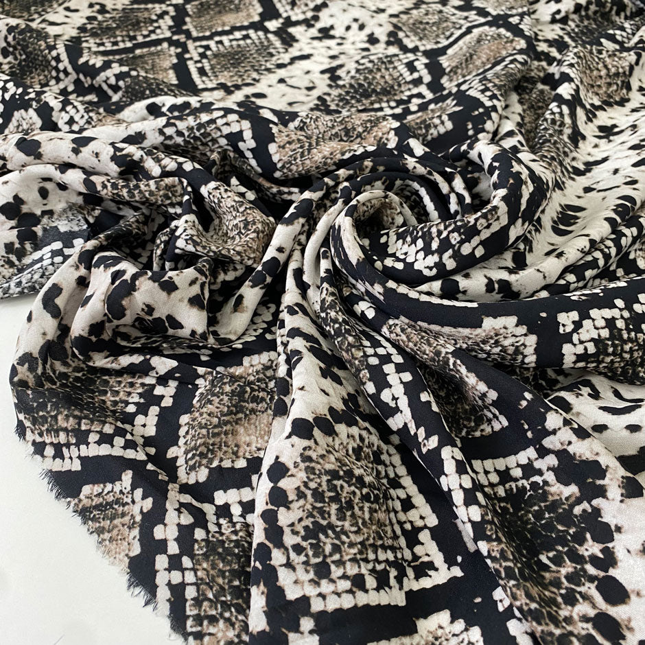 Pure viscose with a snake skin print in beige, black, and mocha tones. Very soft, light, and flowy, not transparent. Ideal for blouses, shirting, dresses, and skirts. High-quality deadstock collected in Stock from a Maison de Couture in Italy.
