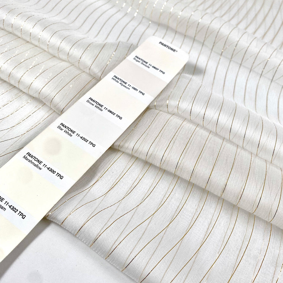 Pure silk chiffon in star white with golden lurex stripes. Very light, soft, flowy, and transparent. Ideal for dresses, skirts, blouses, and shirting. High-quality deadstock collected in Stock from a Maison de Couture in Italy.