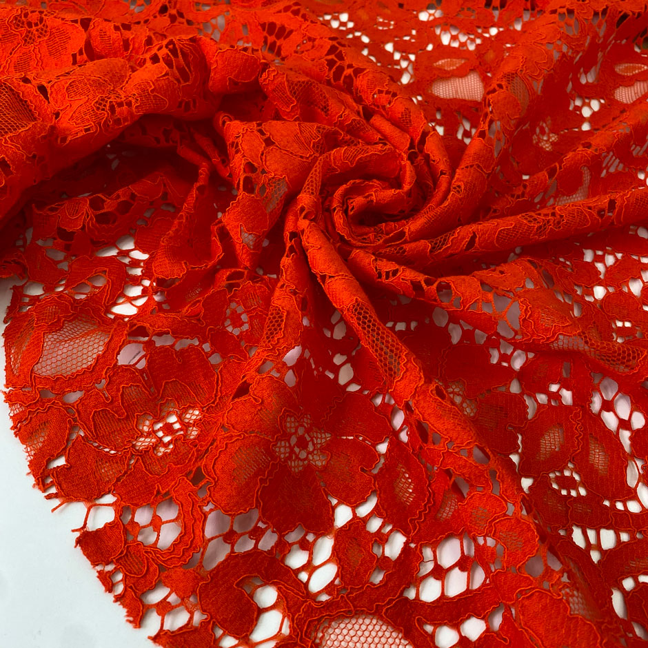 Cotton and polyester lace in tomato red with a delicate flower design, soft and light. Ideal for dresses, blouses, and skirts. High-quality deadstock collected in Stock from a Maison de Couture in Italy.