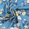 Light blue twill polyester in white and yellow floral design. The fabric is shiny and falling. High-quality deadstock fabric collected in Stock from a Maison de Couture in Italy.