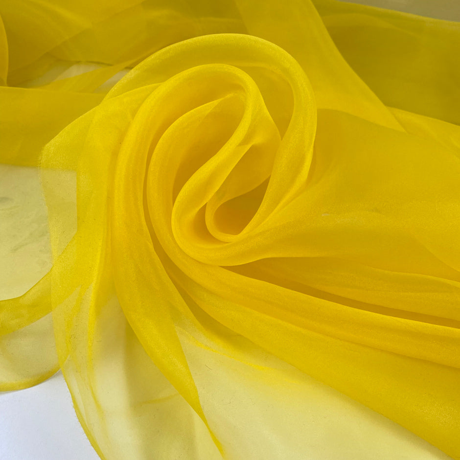 Bright yellow polyester organza transparent and light. High-quality deadstock fabric collected in Stock from a Maison de Couture in Italy.