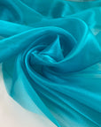Polyester organza very shiny light and transparent, in bright turquoise. High-quality deadstock fabric collected in Stock from a Maison de Couture in Italy.