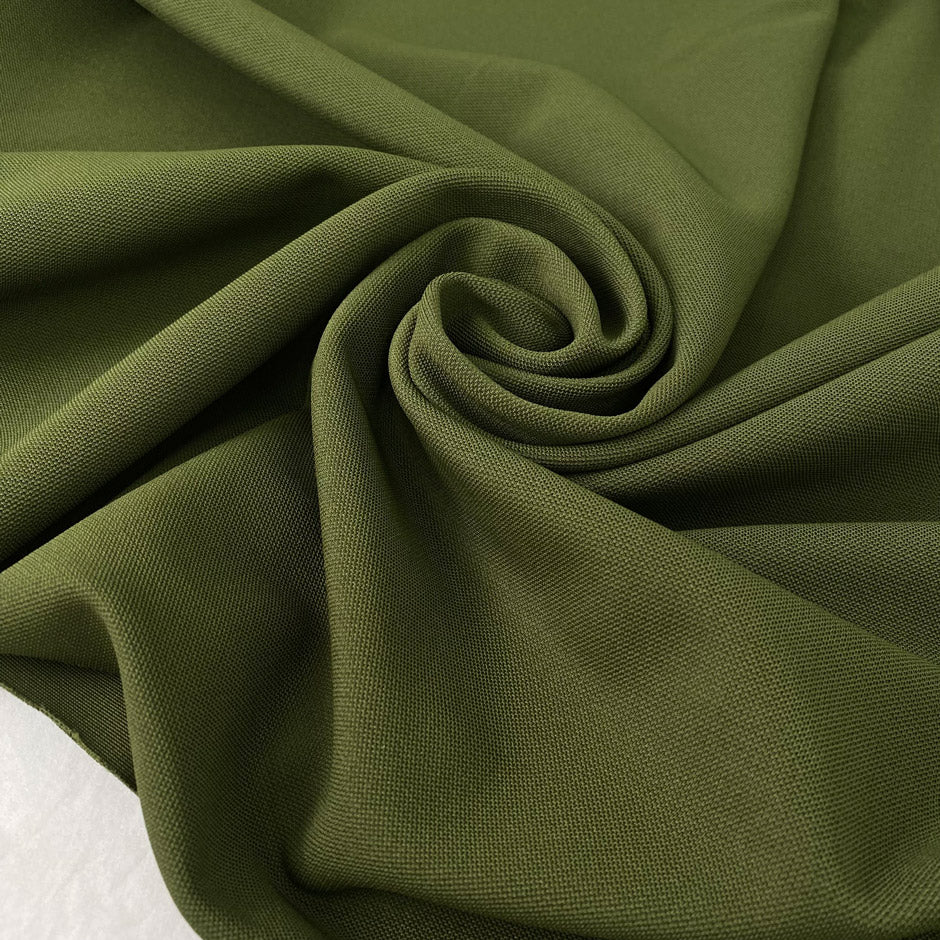 Dark green stretch Punto Milano jersey in polyester and elastane in the shade avocado, slightly heavy and stiff, with a rough texture. Ideal for trousers, skirts, dresses and jackets. High-quality deadstock collected in Stock from a Maison de Couture in Italy.