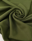 Dark green stretch Punto Milano jersey in polyester and elastane in the shade avocado, slightly heavy and stiff, with a rough texture. Ideal for trousers, skirts, dresses and jackets. High-quality deadstock collected in Stock from a Maison de Couture in Italy.