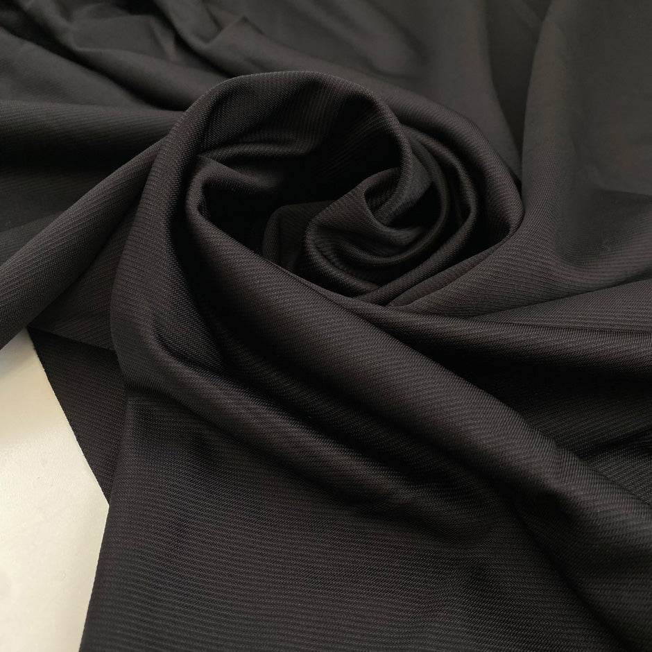 Heavy punto Milano jersey, pure viscose, a little stretch, very flowy in Pirate Black. Ideal for dresses, skirts, and trousers. High-quality deadstock fabric by the meter collected in Stock from a Maison de Couture in Italy.