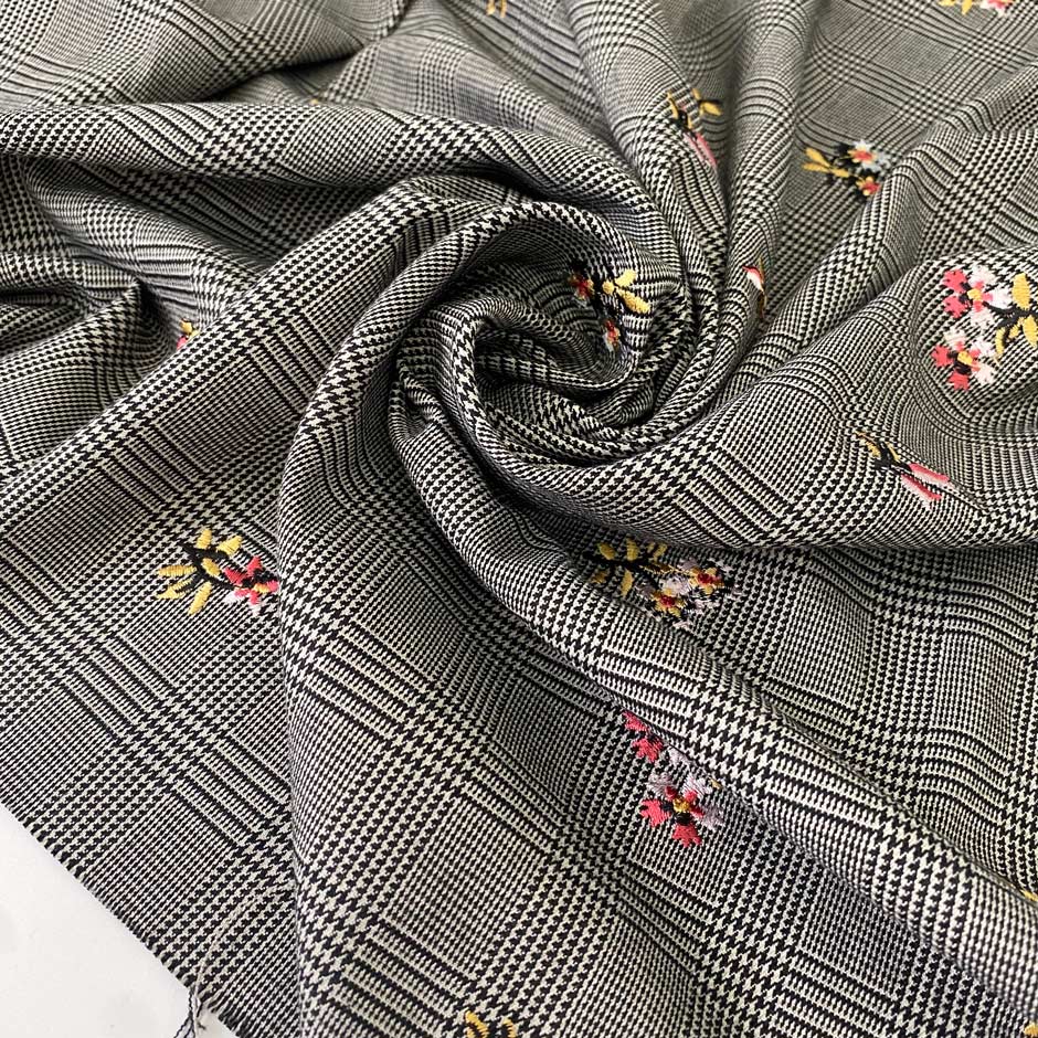 Warm polyester Prince of Wales in black and white with delicate floral embroidery. Ideal for trousers, jackets, dresses, and skirts.High-quality deadstock collected in Stock from a Maison de Couture in Italy.