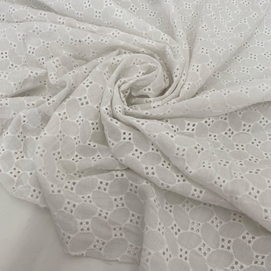 Pure cotton in bright white with geometric square embroidery. Very soft, light, and slightly transparent. Perfect for shirting, dresses, and skirts. High-quality deadstock collected in Stock from a Maison de Couture in Italy.