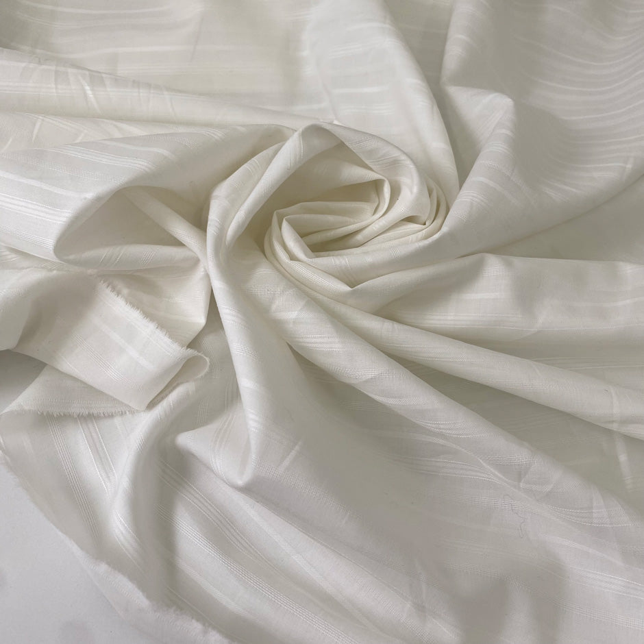 Very soft and light pure cotton batiste in white with delicate stripe design. Ideal for shirting and dresses. High-quality deadstock collected in Stock from a Maison de Couture in Italy.