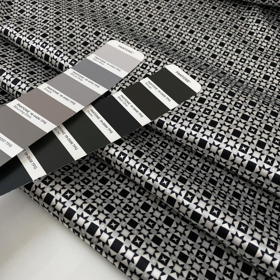 Polyester and elastane satin with small geometric design in shades of grey, white, and black, very soft, light, flowy, not transparent, with a shiny effect. High-quality deadstock collected in Stock from a Maison de Couture in Italy.