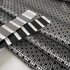 Polyester and elastane satin with small geometric design in shades of grey, white, and black, very soft, light, flowy, not transparent, with a shiny effect. High-quality deadstock collected in Stock from a Maison de Couture in Italy.