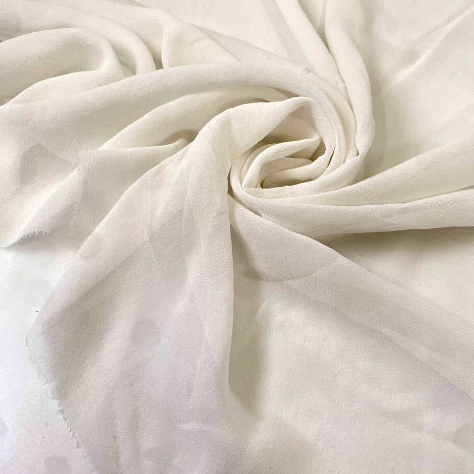 Pure silk georgette in white, color reference Star White. Very soft, light, transparent, and flowy—ideal for dresses, skirts, blouses, and shirting. High-quality deadstock collected in Stock from a Maison de Couture in Italy.