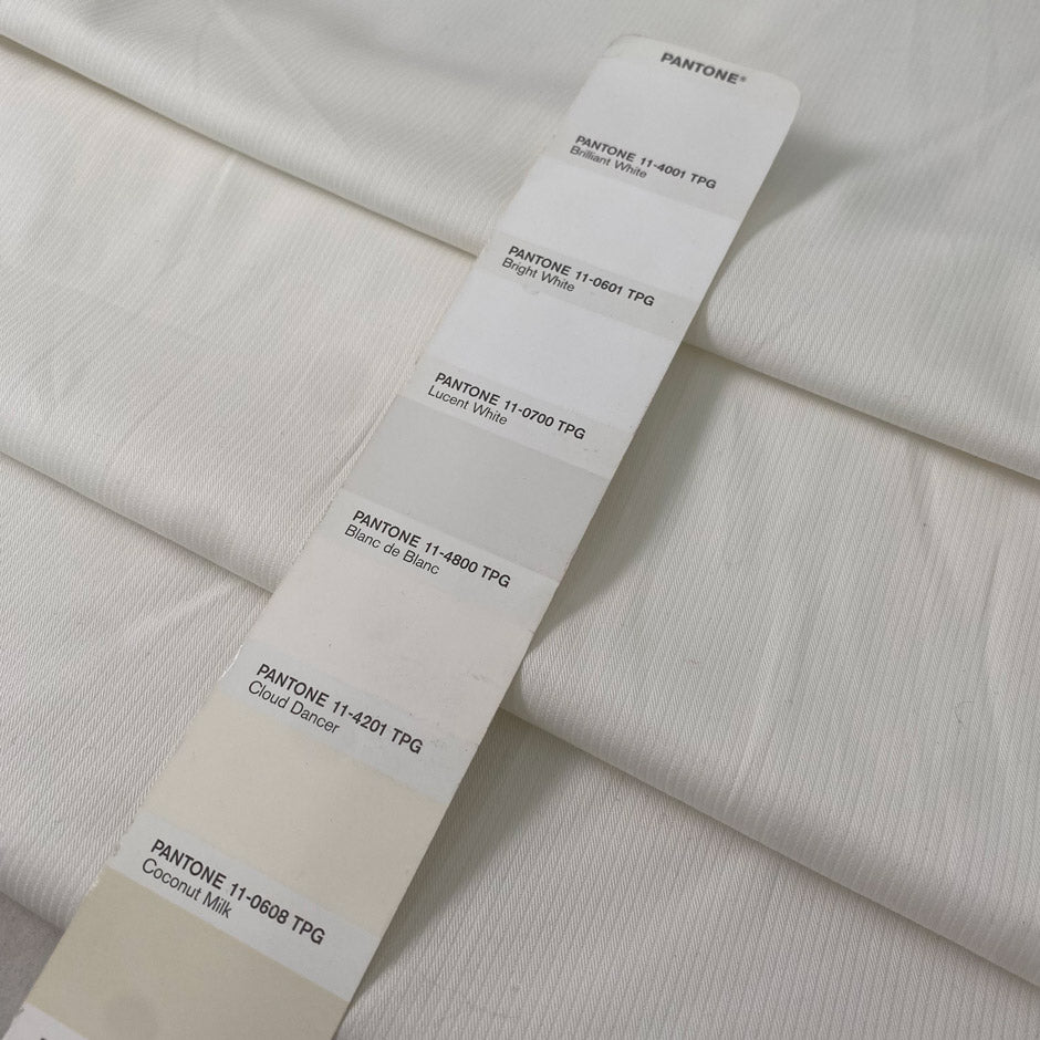 White cotton with elastane in cloudy dancer shade medium weight slightly stiff with striped texture ideal for skirts trousers and jackets. High-quality deadstock collected in Stock from a Maison de Couture in Italy.