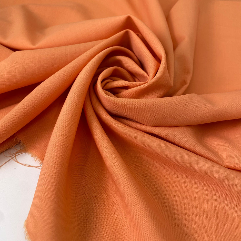 Light wool stretch in orange color reference Copper Tan. Very soft and light, flowy and not transparent. Ideal for dresses, trousers, skirts, and blouses. High-quality deadstock collected in Stock from a Maison de Couture in Italy.