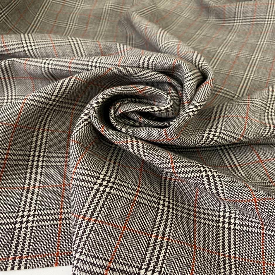 Pure virgin wool with a Prince of Wales check featuring a subtle red line. The pattern combines black, white, and orange tones for a bold yet timeless look. Ideal for jackets, skirts, and dresses. High-quality deadstock collected in Stock from a Maison de Couture in Italy.