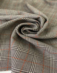 Pure virgin wool with a Prince of Wales check featuring a subtle red line. The pattern combines black, white, and orange tones for a bold yet timeless look. Ideal for jackets, skirts, and dresses. High-quality deadstock collected in Stock from a Maison de Couture in Italy.