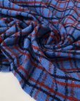 Pure wool twill with check pattern in blue red and dark blue shades blue jasper and molten lava soft and warm ideal for jackets light coats and winter skirts. High-quality deadstock collected in Stock from a Maison de Couture in Italy.