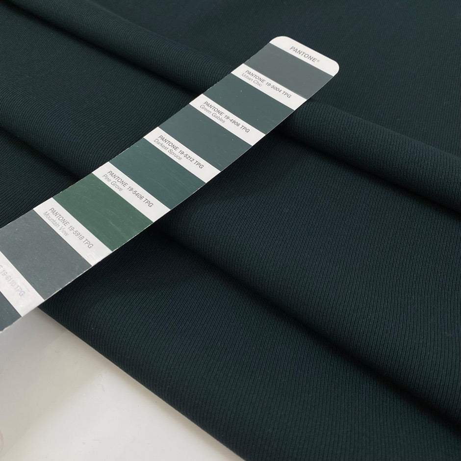 Pure wool in dark forest green with texture. A little bit stiff but flowy and medium weight. Ideal for jackets, skirts, trousers, and light coats. High-quality deadstock collected in Stock from a Maison de Couture in Italy.