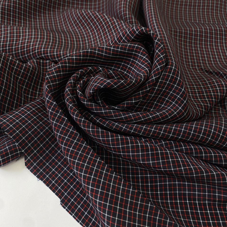 Pure viscose with a check pattern in the shades of black, red, and white. Very soft, flowy, and not transparent. Ideal for skirts and dresses. High-quality deadstock collected in Stock from a Maison de Couture in Italy.