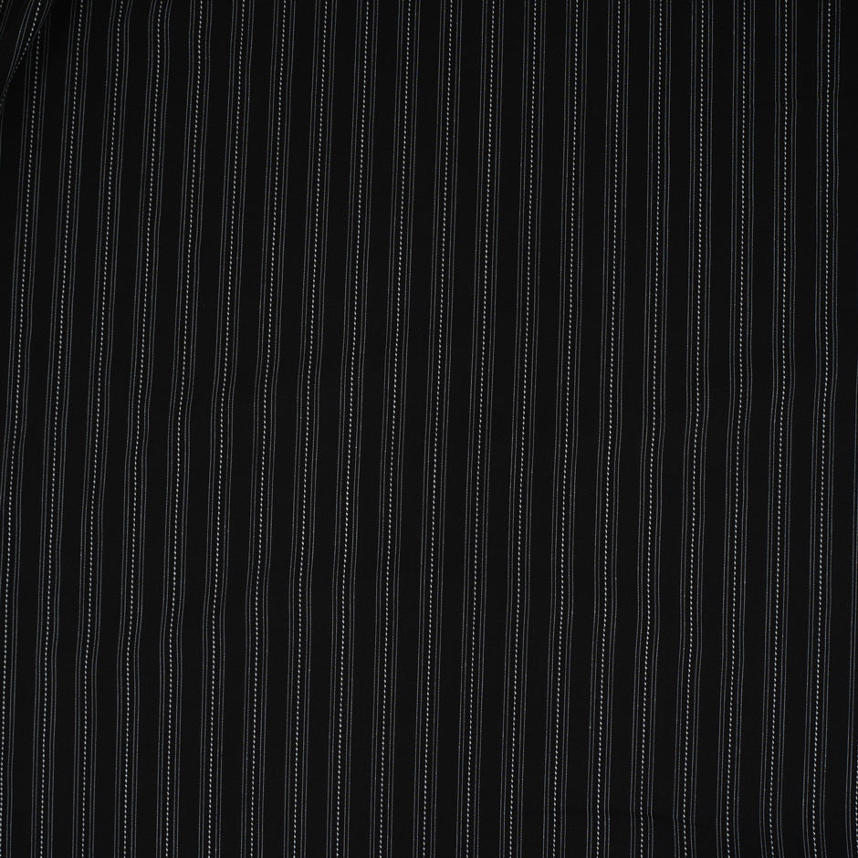 Fabric in black chalk stripe with fine white lines, elegant and slightly structured. Ideal for tailoring, trousers, jackets and skirts. High-quality deadstock collected in Stock from a Maison de Couture in Italy.