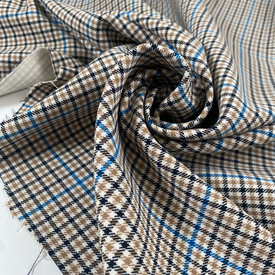 Mixed polyester comfort stretch, with checked design in the shades of beige, color reference natural, and turquoise, color reference fiod blue. A little heavy and flowy, ideal for trousers and jackets. High-quality deadstock collected in Stock from a Maison de Couture in Italy.